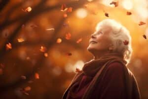 Senior woman gazing up at falling autumn leaves