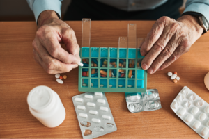 Caregiver helping a senior with medication management to ensure safety in taking the right pill at the right time.