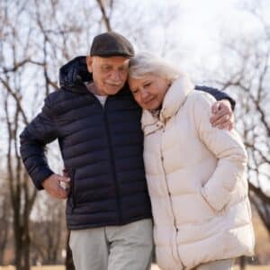 Two seniors enjoying the wintertime by walking as an exercise to ease their joint pain.