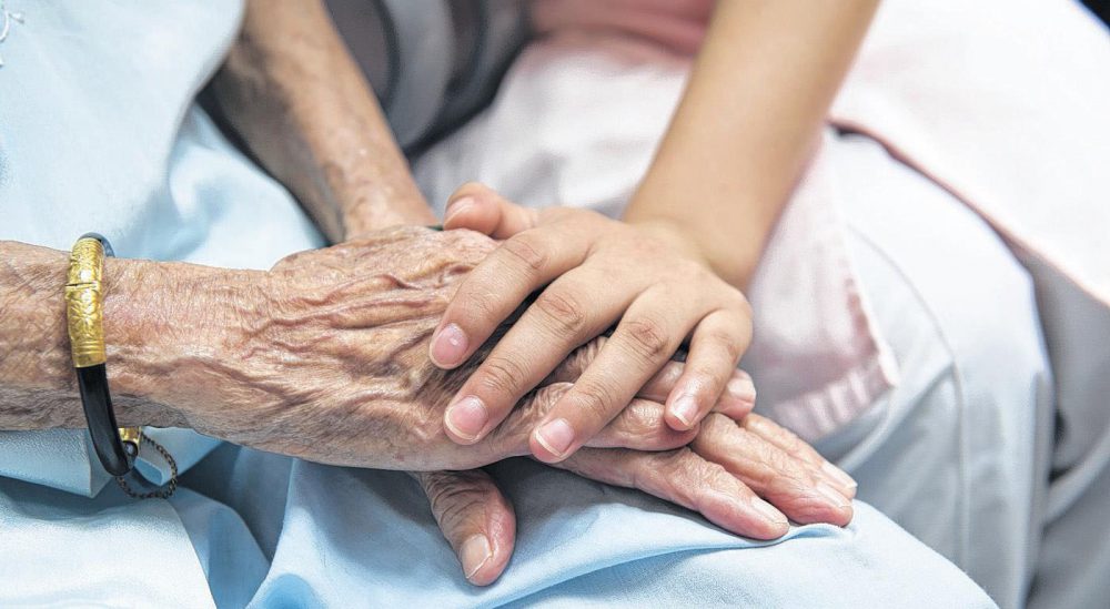 Hands of a senior being helped by a support person who understands and cares