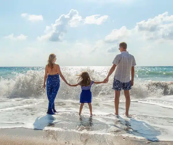 Family having fun on vacation by the ocean knowing the respite caregiver is with their loved one.