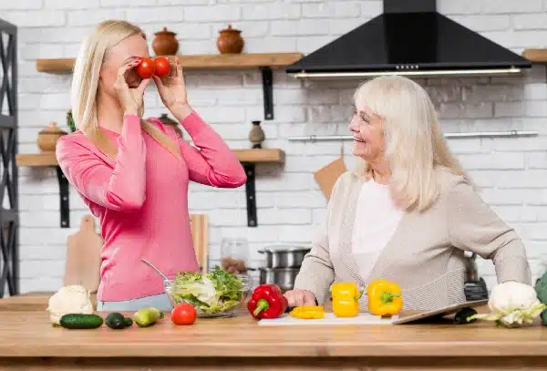 two older women having fun making a healthy salad
